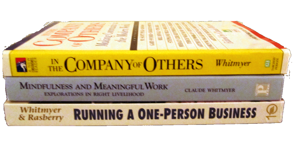 Stack of Claude Whitmyer's three books: In the Company of Others, Mindfulness and Meaningful Work, Running a One-Person Business with spines facing out revealing titles.