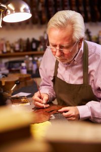 Man Restoring Violin In Workshop