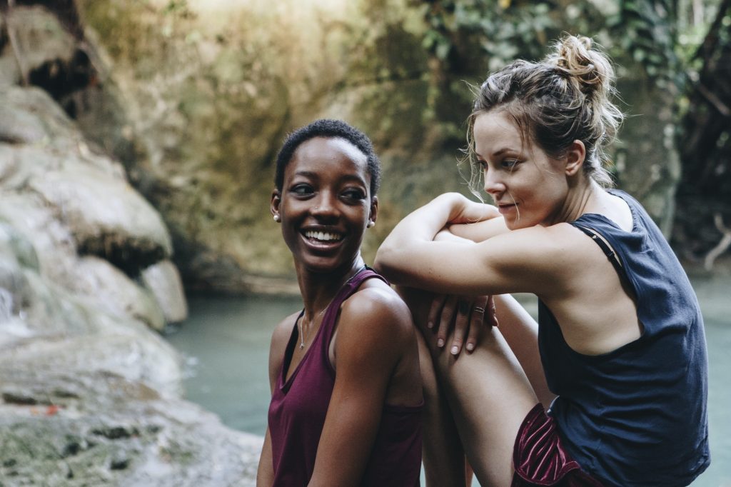 Two friends relaxing by a waterfall